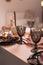 Close up of festive Christmas table setting with empty wine glasses and black plate with gold garnet