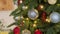 Close-up of a festively decorated Christmas tree with balls on a blurred sparkling fairy background. Defocused garland