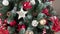 Close-up of a festively decorated Christmas tree with balls on a blurred sparkling fairy background. Defocused garland