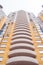 Close-up figured convex balconies of multi-storey yellow modern brick residential building.