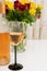 Close-up of filled wine glass and roses in vase