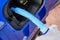 Close up filling of diesel exhaust fluid from canister into the tank of blue car for reduction of air pollution