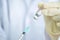 Close up of filling syringe with liquid vaccine in the clinic or laboratory. Scientist wear glove and holding vaccine bottle.