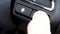 Close up of finger pressing the smart system button voice control i-SMART on the steering wheel when driving.