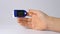 Close-up on a finger, putting on a pulse oximeter to check the pulse of the amount of oxygen in the blood. White background. Diagn