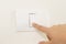 Close up of finger turning off on light switch on wall