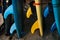 Close up fins blue and yellow surfing longboard with surf leash ready for rent. Set of multicolored boards in a stack by