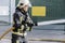 Close-up of a fireman with a hose spreading water in a fire