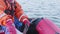 Close up of fishermans hands and legs who pulls fishing net out of water of Kara sea. Net is full of sea weed and a bit