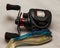 Close up of fishing reel and lures on a plain background