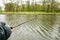 Close-up of a fishing rod in hands. River and forest in the background