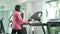 Close up Fitness Asian woman in pink overcoat push button to stop running on track treadmill machine