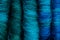 Close-up of five merino wool rolags, in shades ranging from greens to blues