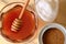 Close up in flat lay angle of a jar of honey next to white sugar and brown sugar bowls