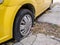 Close up of flat or pierced tires of a yellow car or taxi on a street