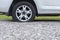 Close up of flat rear tire of white suv track car vehicle automobile punctured by nail. Summer day, residential street.