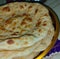 Close up of flat slices of baked roti bread on plate