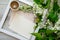 Close-up flatlay with a cup of coffee in white wooden frame and mockup and copyspace pastel pink envelopes and blank postcard