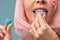 Close up of a flirtatious female model on blue background wearing a pink wig with a candy in mouth. Pretty glamorous