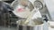 Close-up of flour adding to raw dough in automatic mixer. Female hand in black gloves pouring ingredient in metal bowl