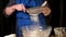 Close-up of flour through a metal sieve fray in nature blur background