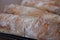 Close up of floury home made ciabatta sour dough loaves cooling on a wire tray, baked during the Coronavirus lockdown.