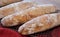 Close up of floury home made ciabatta sour dough loaves cooling on a wire tray, baked during the Coronavirus lockdown.