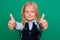 Close-up focus on thumbs up. A schoolgirl shows a gesture of approval, isolated on a green background