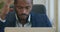 Close-up of focused bearded African American man typing on laptop keyboard and thinking. Portrait of confident young