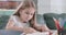 Close-up of focused Caucasian girl doing math at home. Clever schoolgirl doing homework at the table. Education