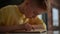 Close-up of focused cute little student boy reading paper book following lines with finger along page sitting at table