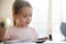 Close up focused little girl reading book, preparing assignments