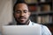 Close up focused young african ethnicity man working on computer.