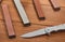 Close-up on a folding knife and various whetstones on wooden background