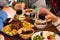 Close up of food and hands taking wine - familiar dinner together or lunch - celebrating something