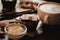 Close up food image of cup of coffee and dessert on the wooden table background in cafe. Trend warm toning. Photo with a small dep