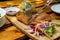 Close Up Food Photo of Knive and Fork being used to cut a Chicken Schnitzel on a Wooden Board with Homemade Potato Salad and