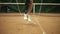 Close up footage of a slender girl with a right leg prosthesis jumping rope on a tennis court in sneakers. Indoors