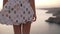 Close up footage of slender woman legs, she walks in slow motion. Blonde woman walking by the cliff very carefully and