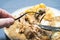 Close-up of a fork with a delicious piece of chicken and a mushroom with mushroom sauce