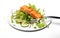 Close-up of fork with food on it: delicious fillet salmon, cucumber, onion, green salad isolated on white background