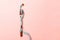 Close up of fork wrapped in measuring tape on pink background. Overweight and overeating concept