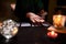 Close-up of fortune-teller& x27;s hands, fortune-telling cards, ball of predictions on black table