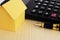 close up Fountain pen and calculator and yellow paper house on wooden table background