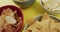 Close up of four bowls full of variety of chips on yellow surface