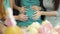 Close-up of four female caucasian hands with colorful manicure caressing belly of the expectant woman. Young women