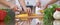 Close-up of four human hands are cooking in a kitchen. Friends having fun while preparing fresh salad. Vegetarian