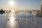 Close up of four ouzo stemmed glasses on a white stand during sunset