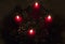 Close up of four red candles burning on advent wreath on evening. Merry Christmas, Advent crown decoration, 4th sunday, Christmas