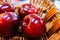 Close up of  four red dotted shiny isolated dessert apples in wicker reed basket